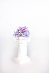 a bouquet of flowers on a pedestal. Lilac on a white background
