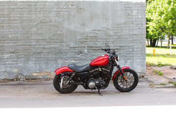 Obraz na płótnie Canvas a red motorcycle near a brick wall. Parking near the building is a hipster urban hobby