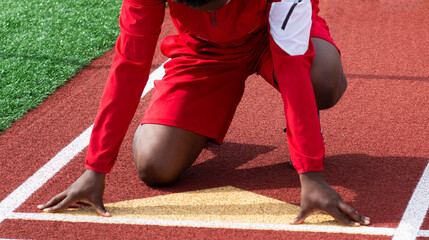 Runner on a track in lanes ready to sprint at practice