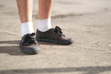 Naklejka premium Male student wearing black sneakers Standing in the sun By choosing to shoot only the legs and shoes