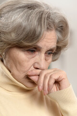 Close up portrait of sad senior woman at home