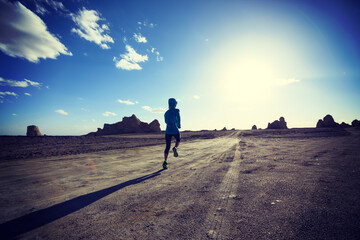 Fitness woman trail runner cross country running on sand desert