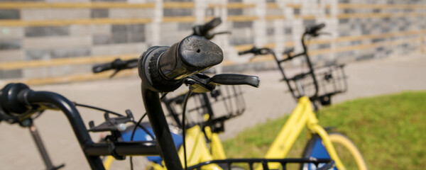 Steering wheel with black handle of rental bike on urban rent station
