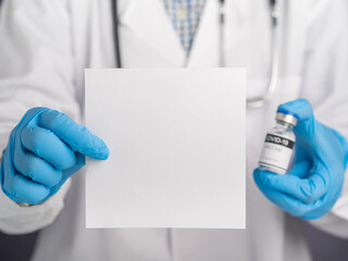 A doctor holding a white paper blank and a COVID-19 vaccine. Vaccine for immunization, and treatment from virus infection. Concept of medical and the fight against the virus