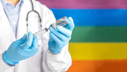 A doctor in blue gloves holding a bottle with the vaccine while standing with the rainbow (LGBT)...