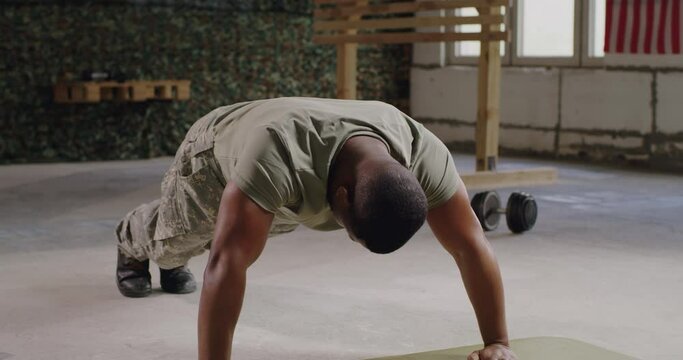 Black military man doing push ups in gym