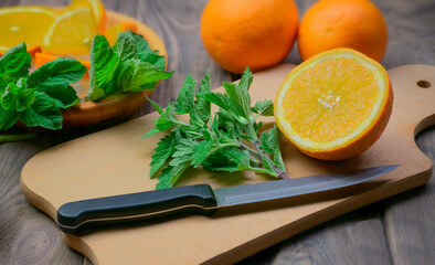 Delicious orange lemonade with soda water and mint on old wood table, space for text. Fresh summer cocktail.