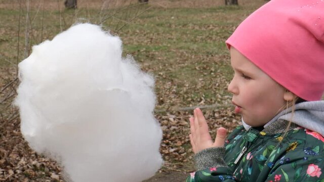 Child girl eating cotton candy
