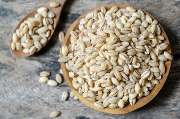 Top view of dry organic wheat seeds pile in wooden bowl and grunge background