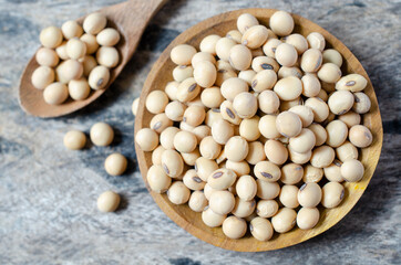 Top view of dry organic soybean seeds in wooden bowl on grunge background