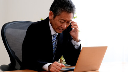 電話で取引先に謝罪するシニア社長