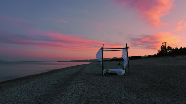 Letto a baldacchino sulla spiaggia vicino al mare calmo