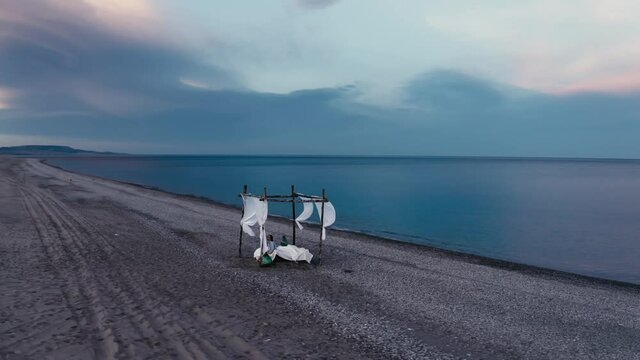Letto a baldacchino sulla spiaggia vicino al mare calmo