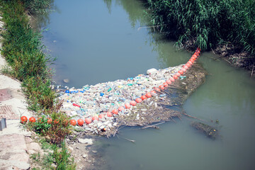 Barrier to stop floating garbage in the river. Environmental protection concept