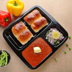 Pav bhaji is a fast food dish from India, consists of a thick vegetable curry served with a soft bread roll, served in a plate