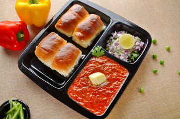 Pav bhaji is a fast food dish from India, consists of a thick vegetable curry served with a soft bread roll, served in a plate