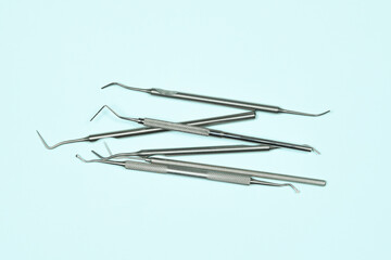 Some medical dental instruments on light blue background. Flat lay closeup top view on dental equipment. Dental probes and explorers