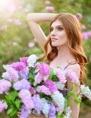 portrait of beautiful young woman  posing with lilacs