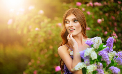 Naklejka premium portrait of beautiful young woman posing with lilacs