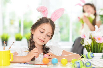 cute girl painting eggs for Easter holiday