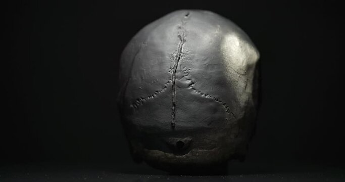 Black skull rotating against black background