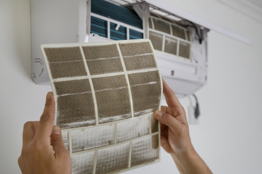 Man holding very dirty air conditioner filter