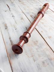wooden baroque flute or recorder isolated on wooden background, vertical image