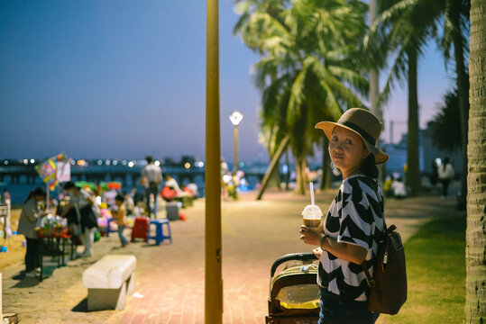 Young woman sits on beach when evening at Zhanjiang, Guangdong, China