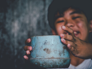 Child or poor homeless holding plastic bowl with hungry and asking people help food donation from...