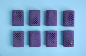 Hair curlers on turquoise background, flat lay. Styling tool