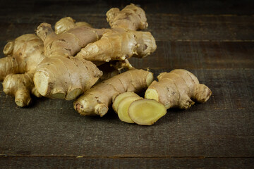 Fresh ginger and sliced on rustic wooden background. The scientific name is zingiber officinale. Herbs for health care concept.