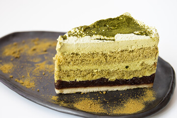 Matcha Green tea Cake pm a rustic ceramic plate, white background