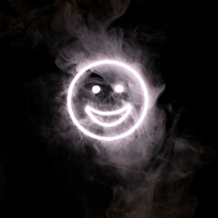 Stylized face expressing emotion glows through the stream of smoke in the dark