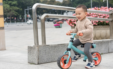 Asian women and their sons ride a balance car in the square