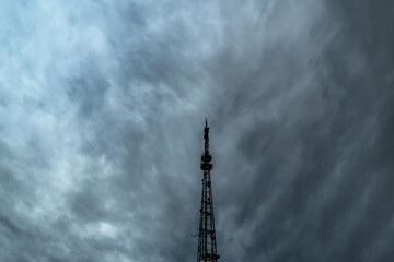 A television or radio broadcasting antenna against a dramatic overcast sky.A cloudy sky with thick...