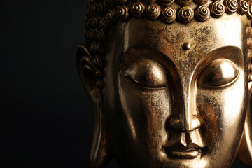 Fototapeta na wymiar Beautiful golden Buddha sculpture on black background, closeup. Space for text