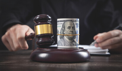 Male judge with a judge gavel and money.
