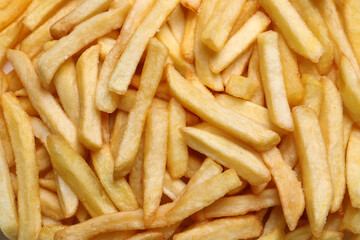 Yummy French fries as background, top view