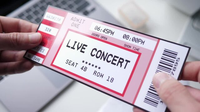 Holding a Live concert ticket in the hands. Closeup shot on the ticket.