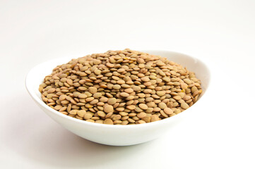 white cup full of lentils on white background