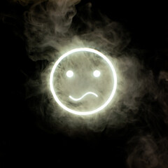 Stylized face expressing emotion glows through the stream of smoke in the dark