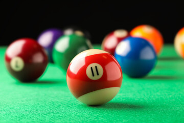 Billiard ball with number 11 on green table, closeup