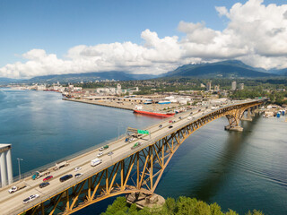 Fototapeta premium Aerial view of an Industrial Site and Second Narrows Bridge during a sunny spring day. Taken in Vancouver, British Columbia, Canada.