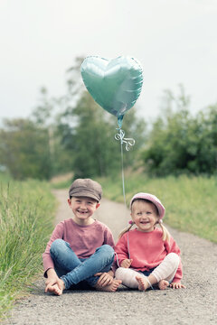 zwei Kinder mit Herzballon