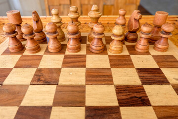 Wooden chess boards and white chess pieces with typical Balinese carvings. Standby for battle.