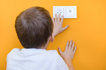 Dangerous situation at home. Child playing with electrical socket.