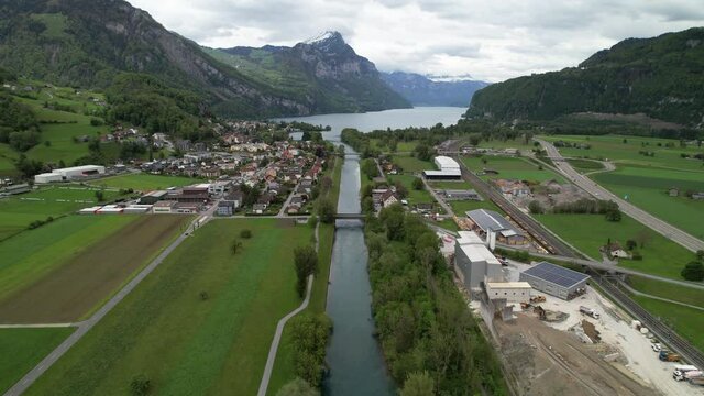 Straight canal leading to a beautiful mountain lake in Switzerland, aerial