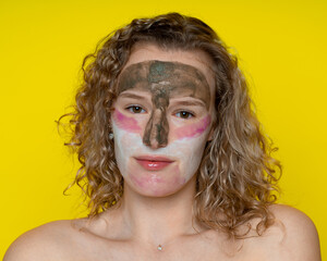 Girl with curly hair in the cosmetic, caring mask of three colors