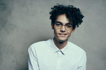 portrait of a happy guy with glasses curly hair white shirt photoshoot model