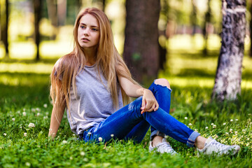 Beautiful, slender girl walks in the park, dressed in a sporty style